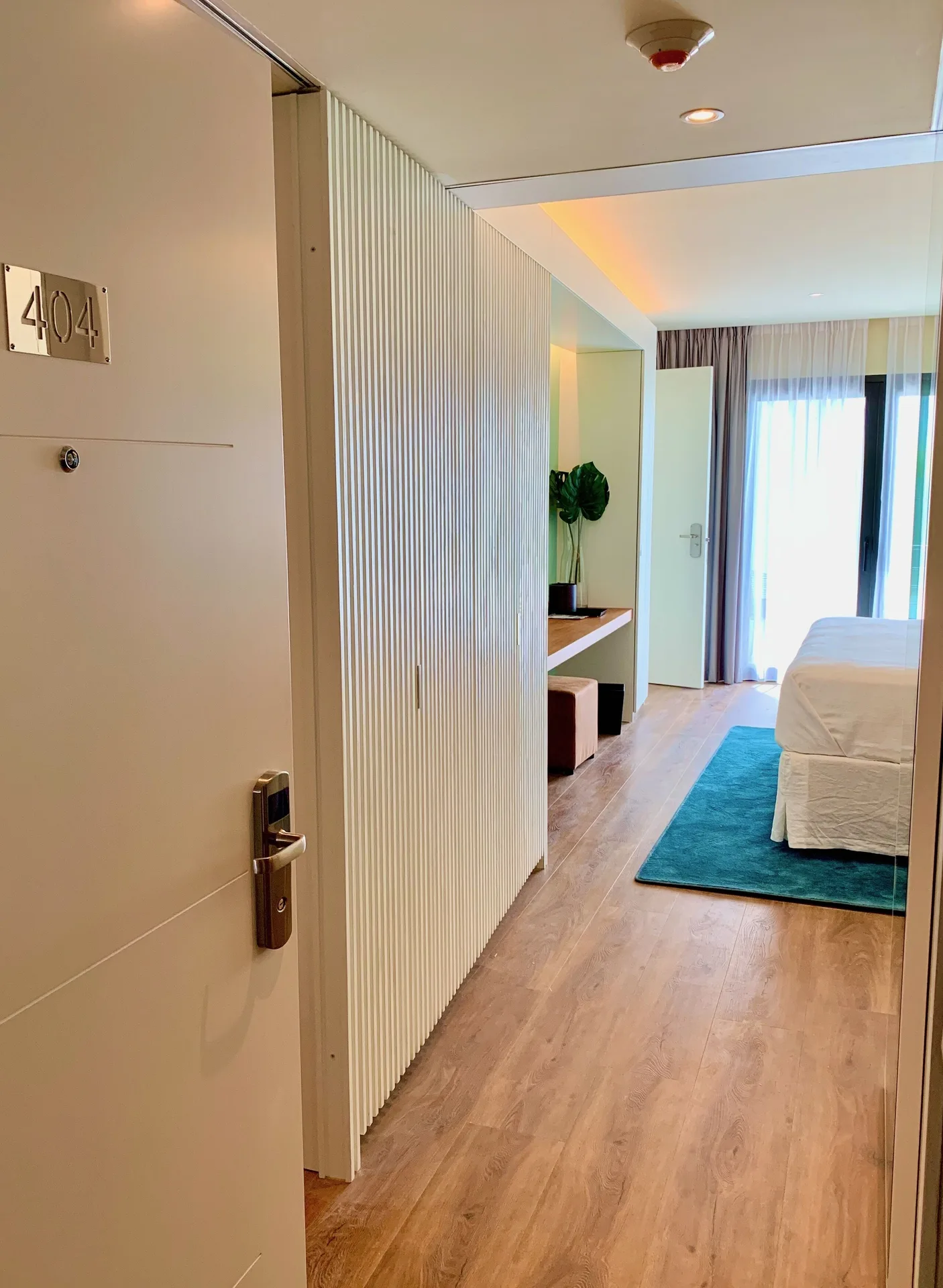 Executive Suite City View entry with room door 404 and bed beyond at Holland House Beach Hotel.
