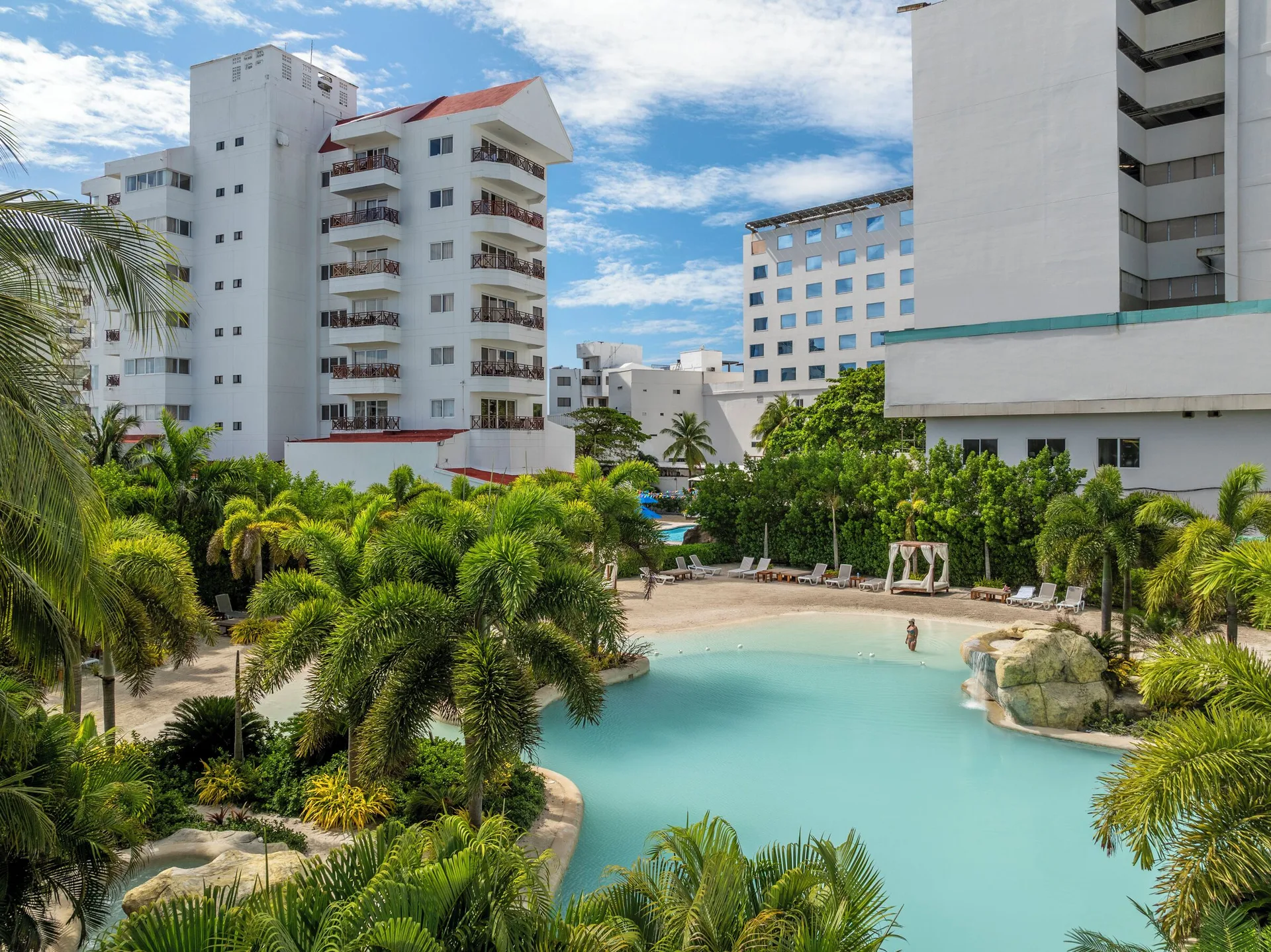 Elevated view of the pool, palms, and resort buildings at Hotel Arena Blanca.