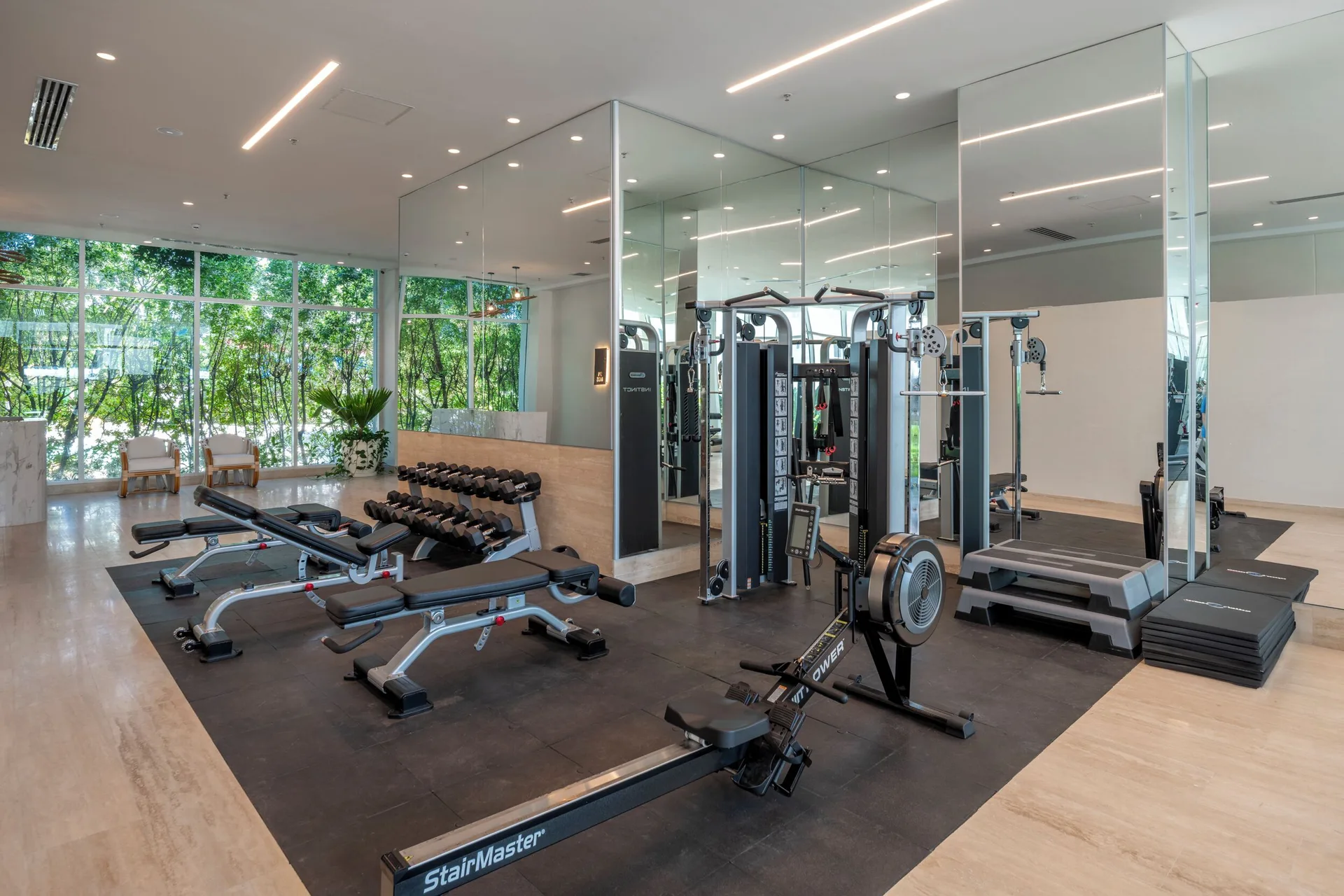 Fitness area with rowing machine, weights, and mirrored walls at Hotel Arena Blanca.