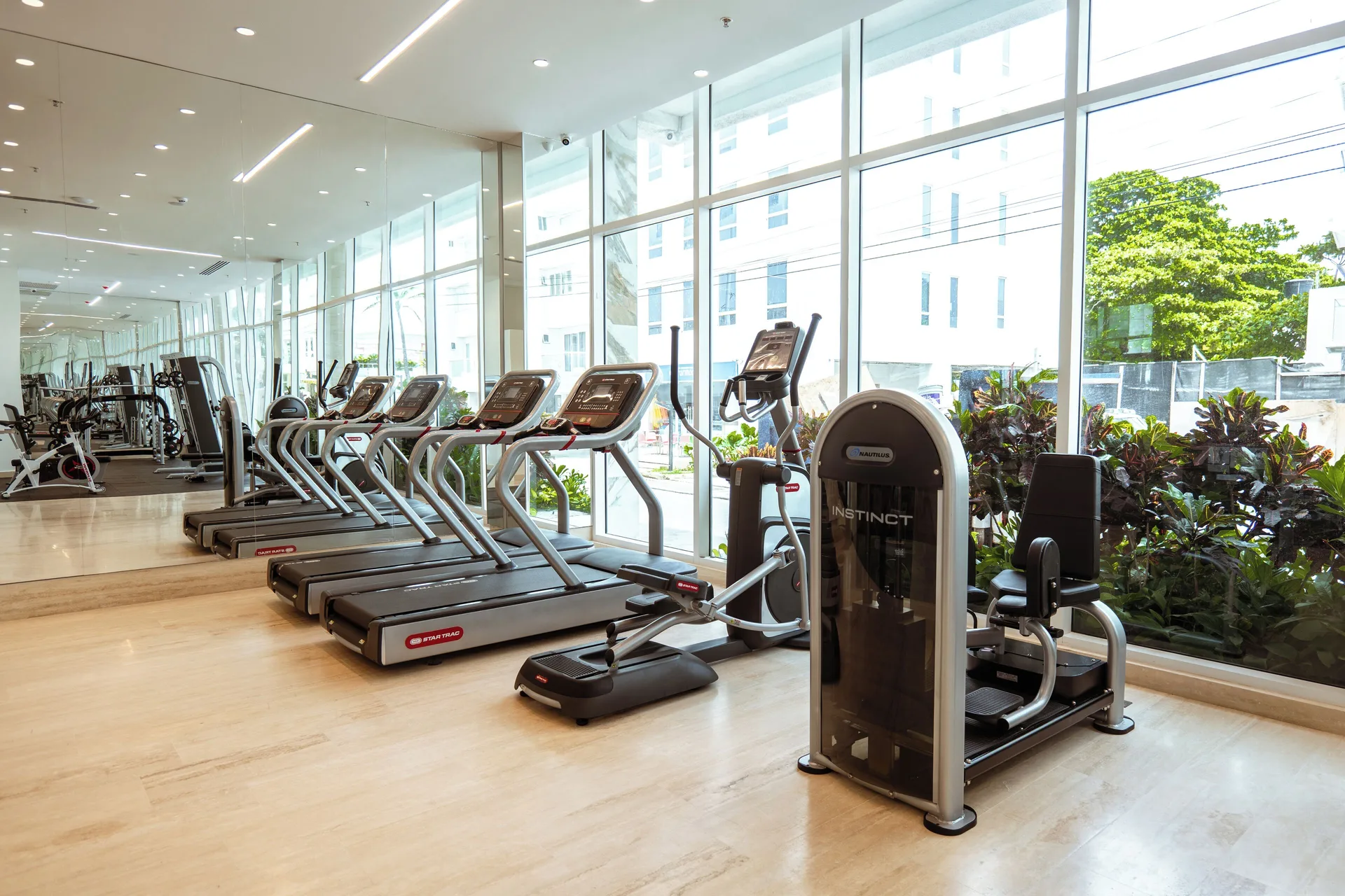 Fitness room with treadmills, cardio machines, and large windows at Hotel Arena Blanca.
