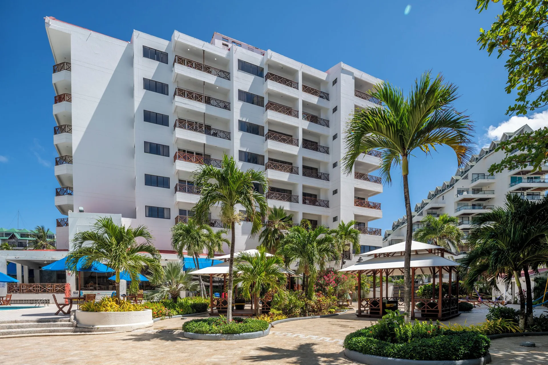 White resort building, garden paths, palms, and gazebos at Hotel Arena Blanca.