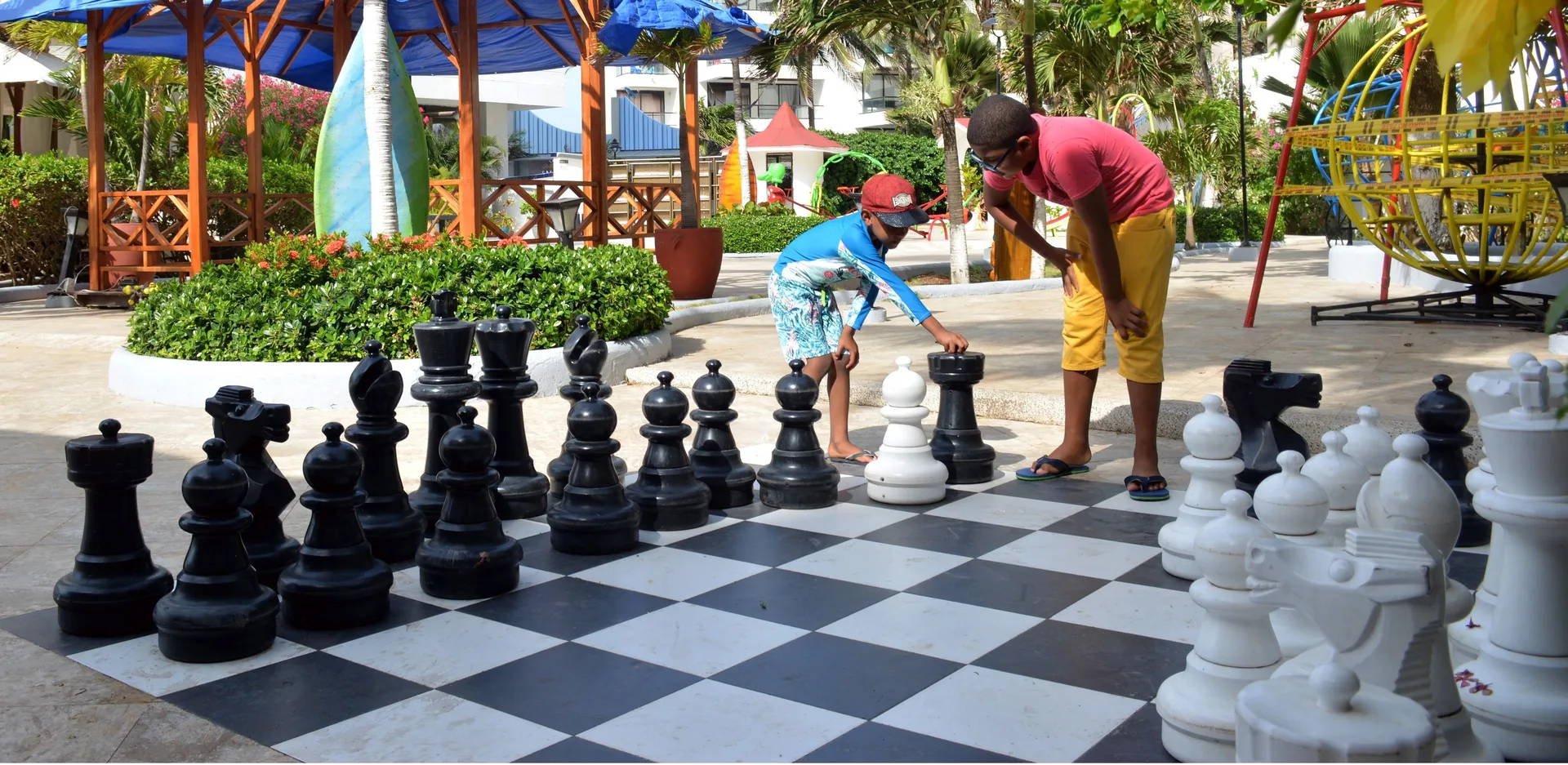 Guests playing giant outdoor chess in the gardens at Hotel Arena Blanca.