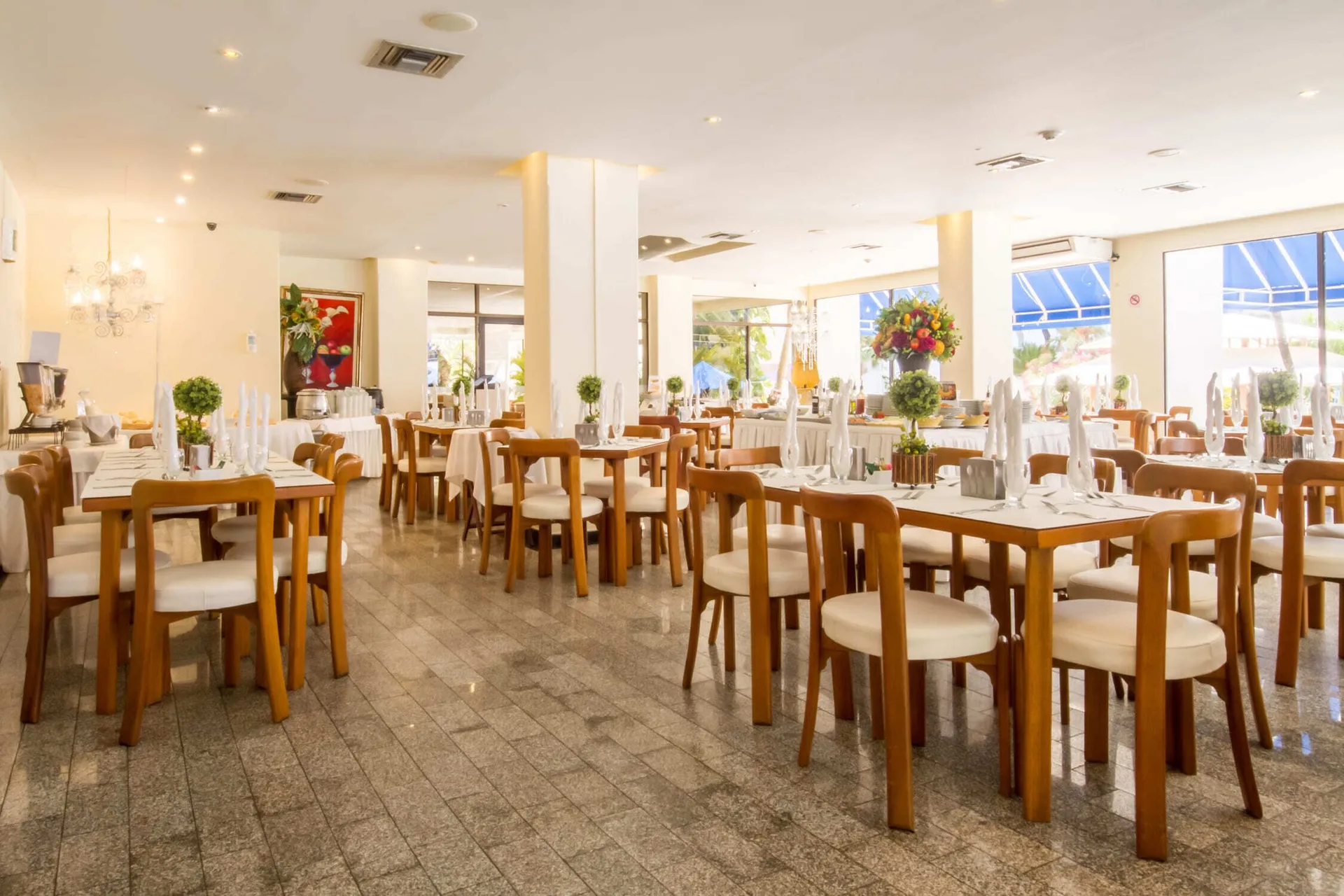 Restaurant dining room with set tables and wooden chairs at Hotel Arena Blanca.