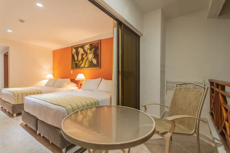 Standard Quadruple Room opening to a balcony seating area at Hotel Arena Blanca.
