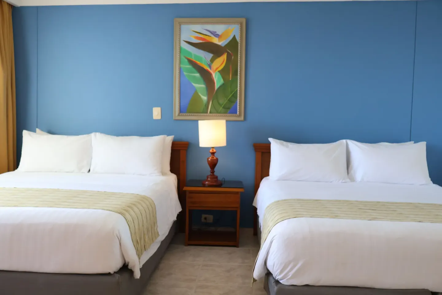 Standard Quadruple Room with two double beds and central nightstand at Hotel Arena Blanca.