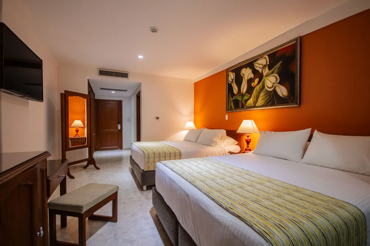 Standard Quadruple Room with two double beds and orange accent wall at Hotel Arena Blanca.