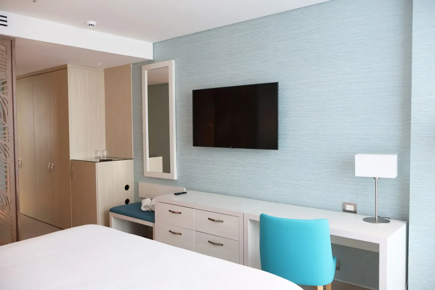 Superior Room desk, TV, dresser, and bed edge at Hotel Arena Blanca.
