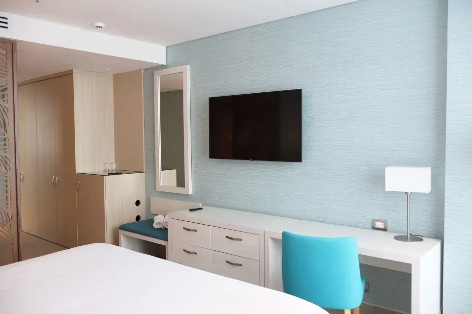 Superior Room desk, TV, dresser, and bed edge at Hotel Arena Blanca.