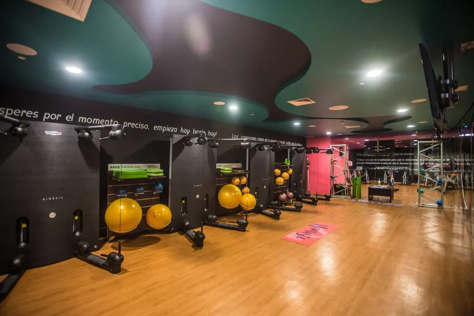 Fitness studio with wall equipment, exercise balls and wood flooring at Hotel Azul Ixtapa Grand Resort Spa.
