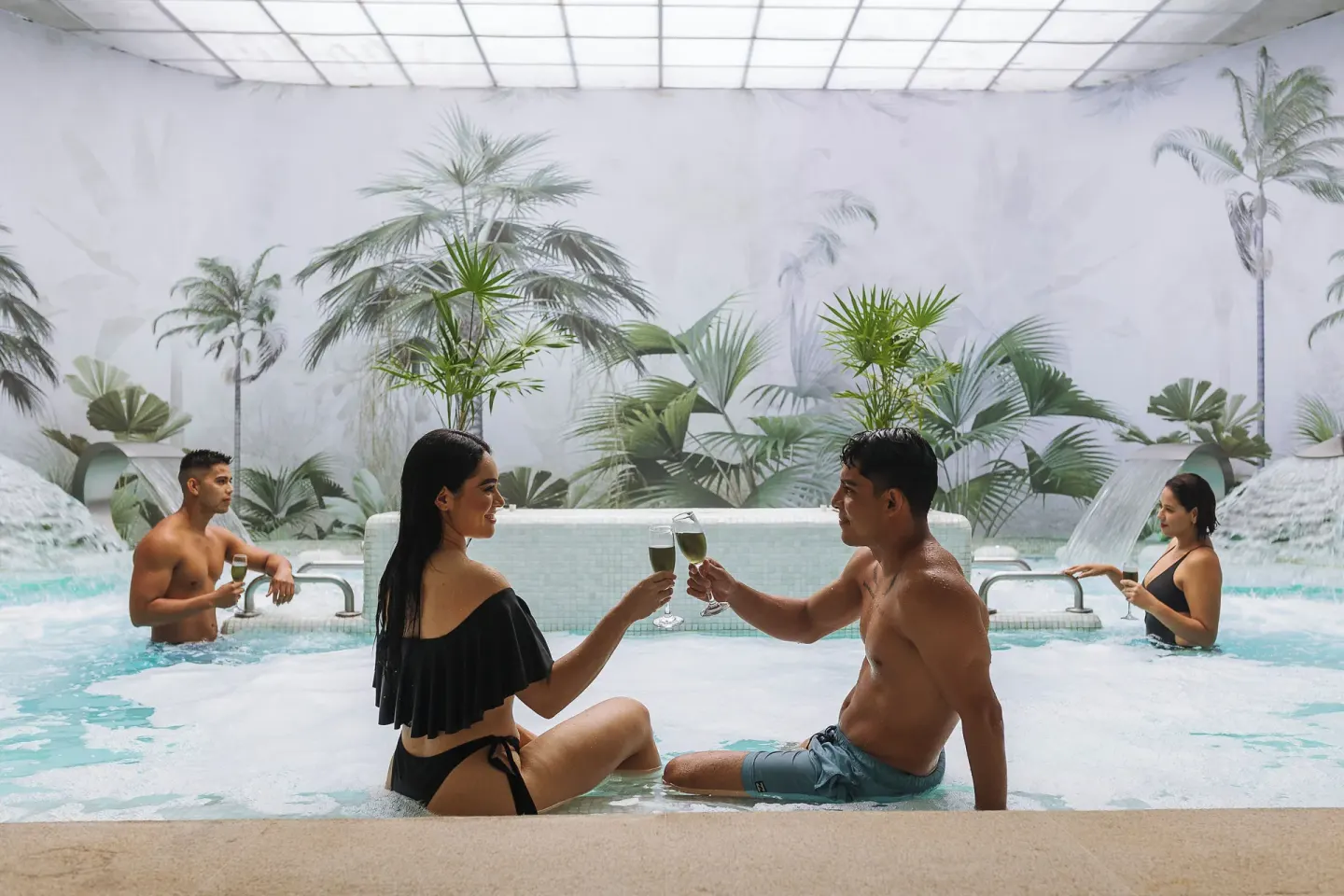 Indoor spa pool with guests and tropical wall art at Hotel Azul Ixtapa Grand Resort Spa.