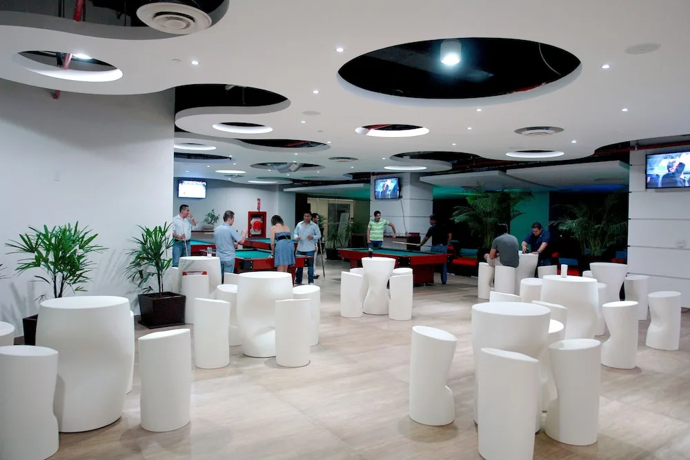 Modern lounge with white seating and billiards at Hotel Azul Ixtapa Grand Resort Spa.