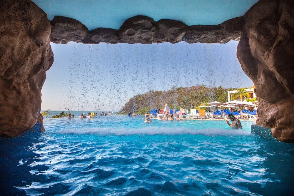 Pool waterfall viewed from a grotto at Hotel Azul Ixtapa Grand Resort Spa.