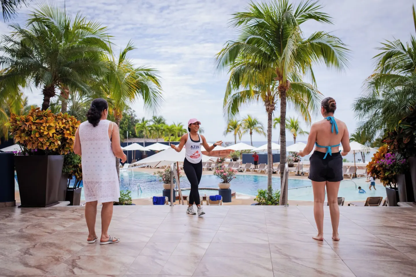 Poolside fitness activity with palm trees at Hotel Azul Ixtapa Grand Resort Spa.