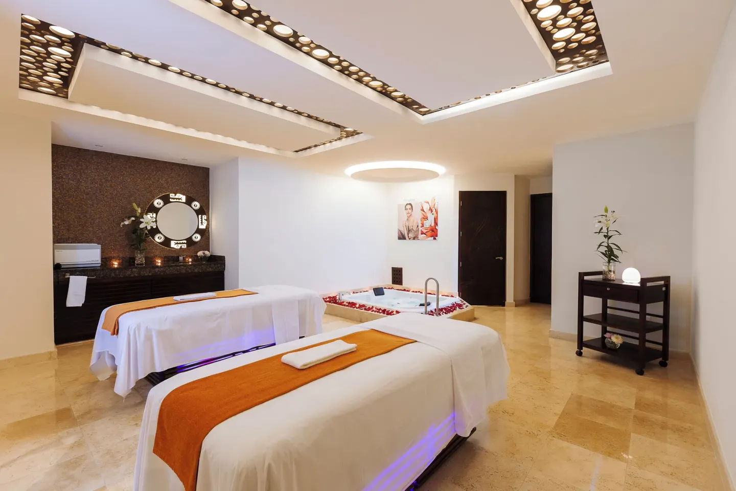 Spa treatment room with two massage tables and soaking tub at Hotel Azul Ixtapa Grand Resort Spa.
