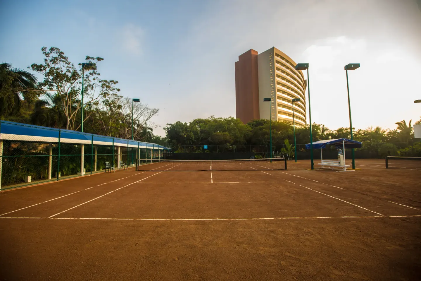 Tennis court with resort tower in the background at Hotel Azul Ixtapa Grand Resort Spa.
