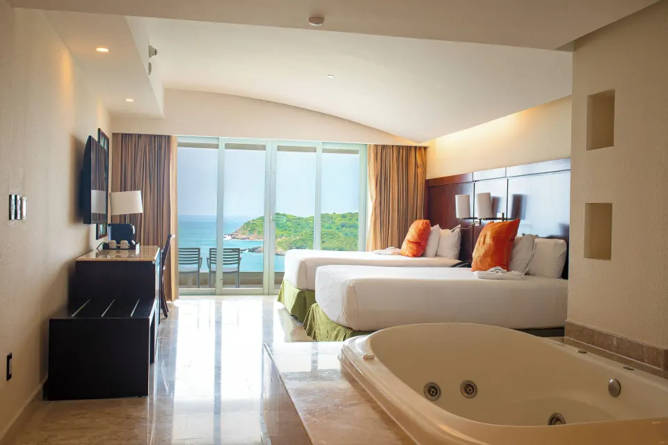 Luxury Suite with two beds, balcony seating, and jetted tub at Hotel Azul Ixtapa Grand Resort Spa.