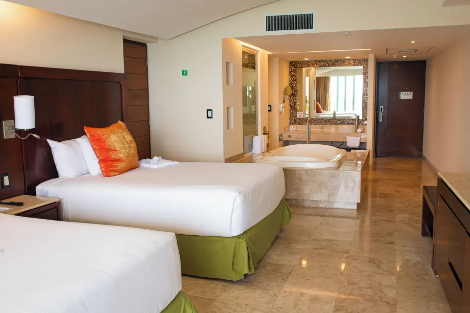 Luxury Suite with two beds and open bathroom area at Hotel Azul Ixtapa Grand Resort Spa.