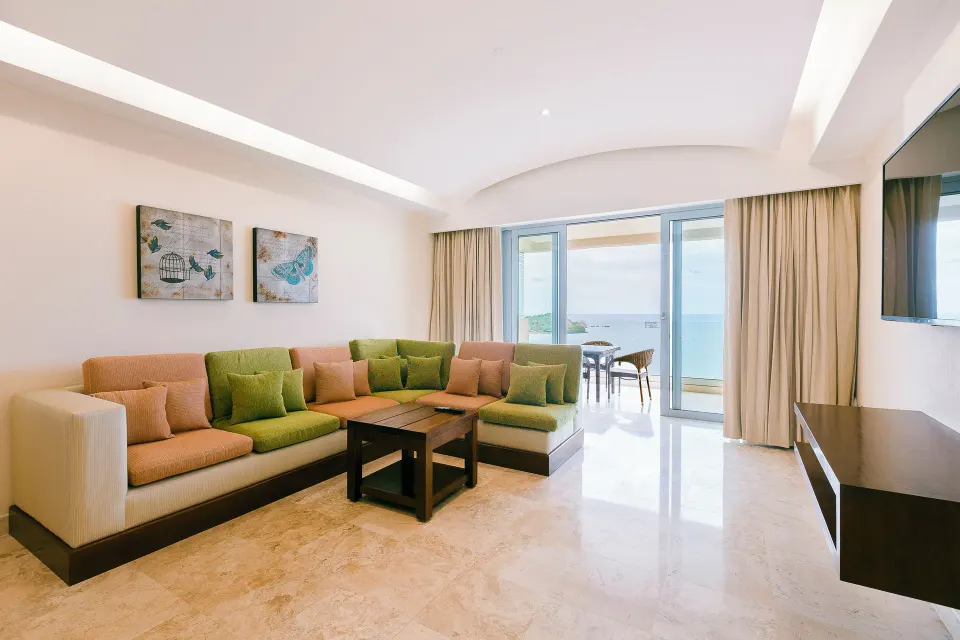 Master Suite living room with sectional sofa and ocean-facing balcony at Hotel Azul Ixtapa Grand Resort Spa.