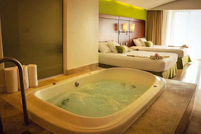 Guest room with two beds and a large in-room jetted tub at Hotel Azul Ixtapa Grand Resort Spa.