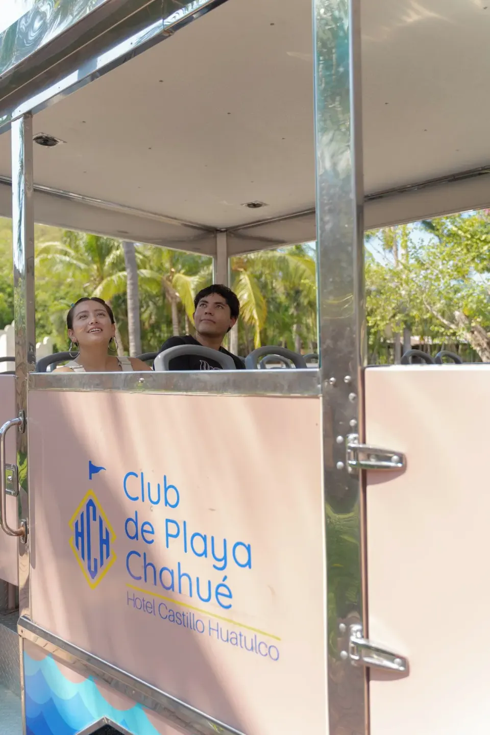Beach club shuttle tram with seated guests at Hotel Castillo Huatulco & Beach Club.