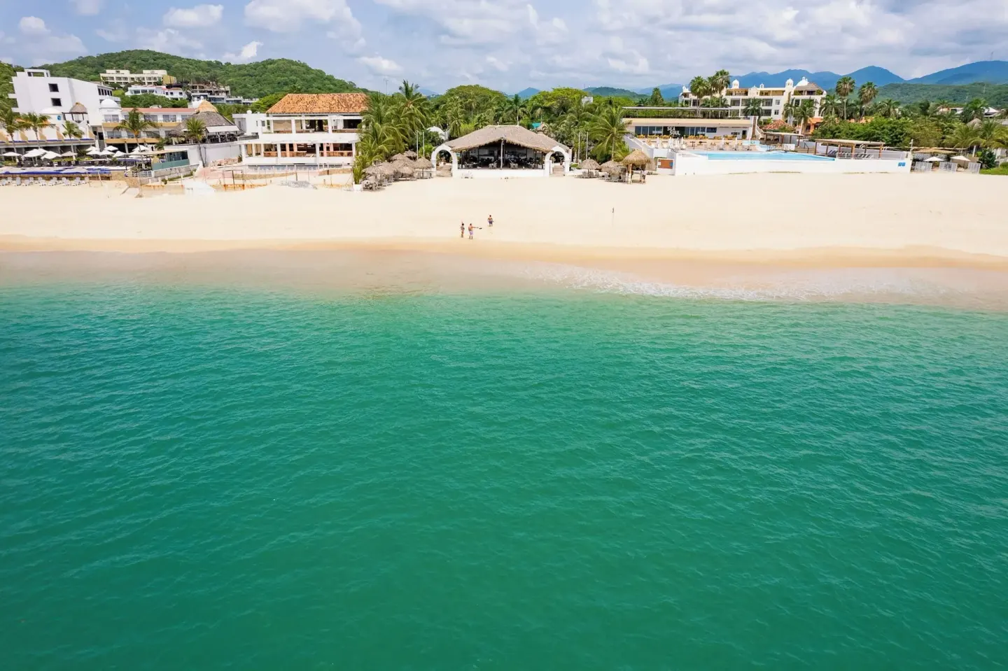 Aerial view of the beachfront and turquoise water at Hotel Castillo Huatulco & Beach Club.