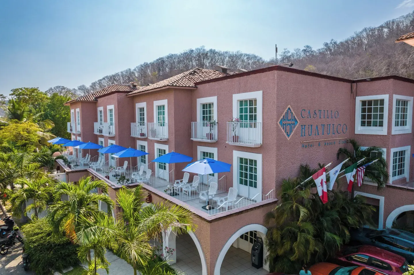 Pink hotel exterior with balconies at Hotel Castillo Huatulco & Beach Club.