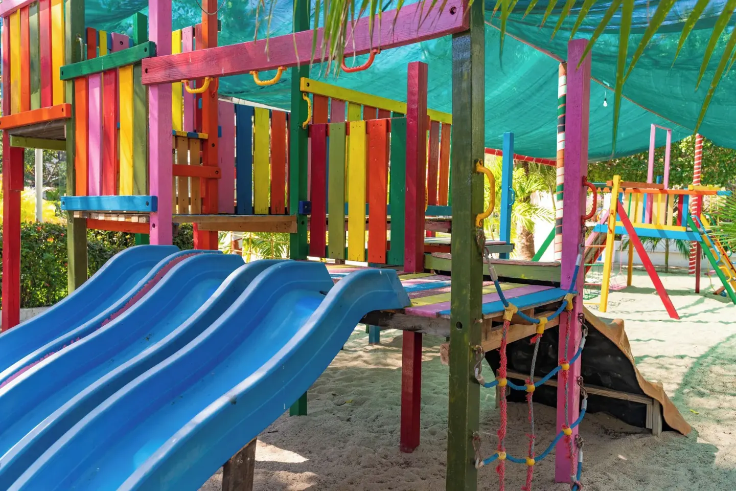 Blue slide and colorful playground platforms at Hotel Castillo Huatulco & Beach Club.