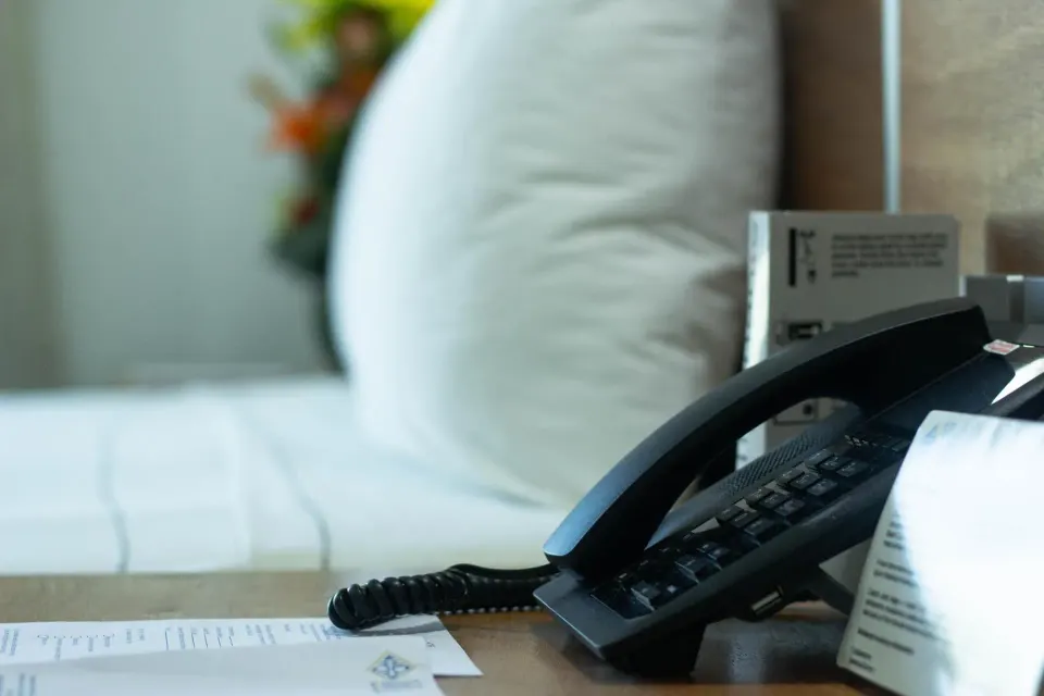 Standard room bedside telephone beside the bed at Hotel Castillo Huatulco & Beach Club.