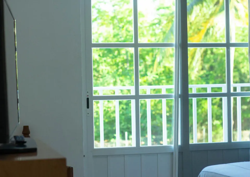 Standard room window with balcony railing and greenery at Hotel Castillo Huatulco & Beach Club.