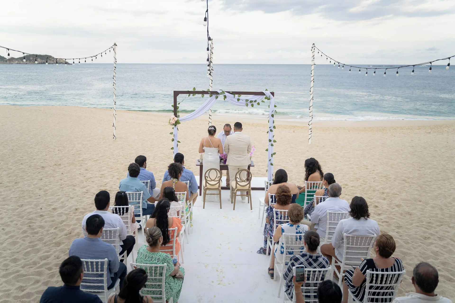 Beach wedding ceremony facing the ocean at Hotel Castillo Huatulco & Beach Club.