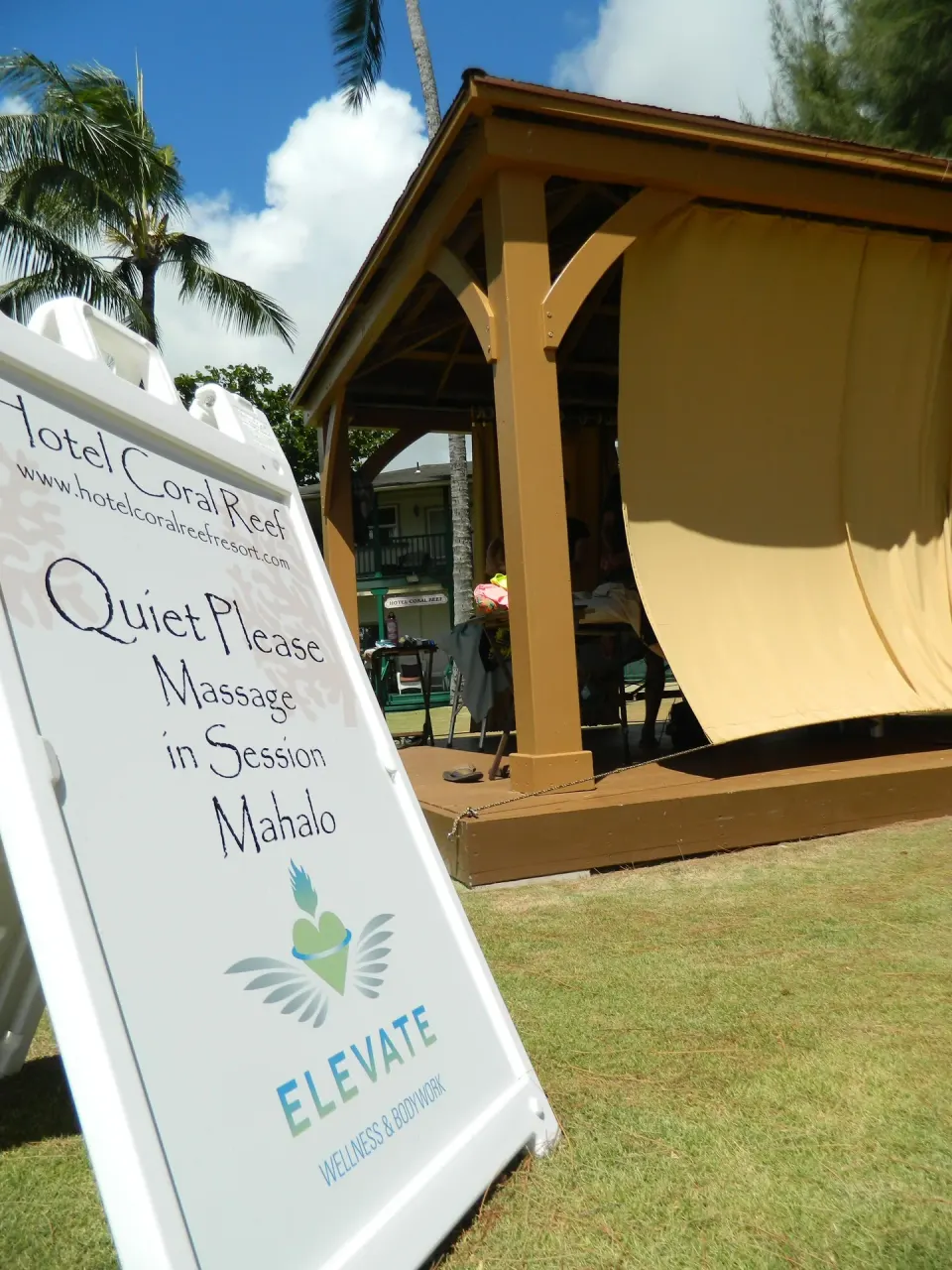 Massage-in-session sign beside a cabana at Hotel Coral Reef.