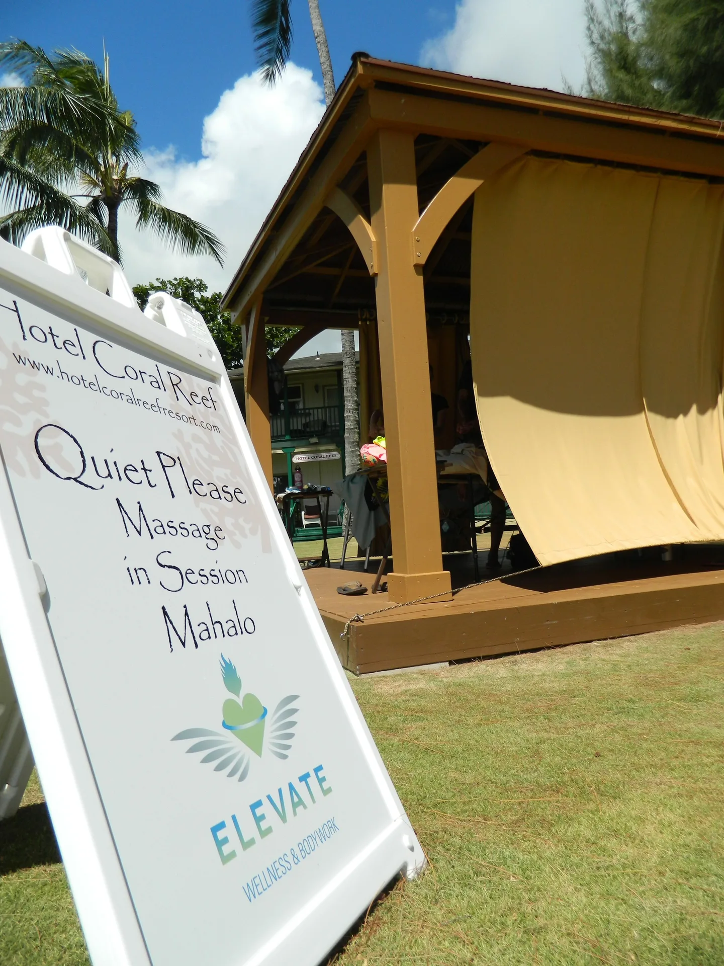 Massage-in-session sign beside a cabana at Hotel Coral Reef.