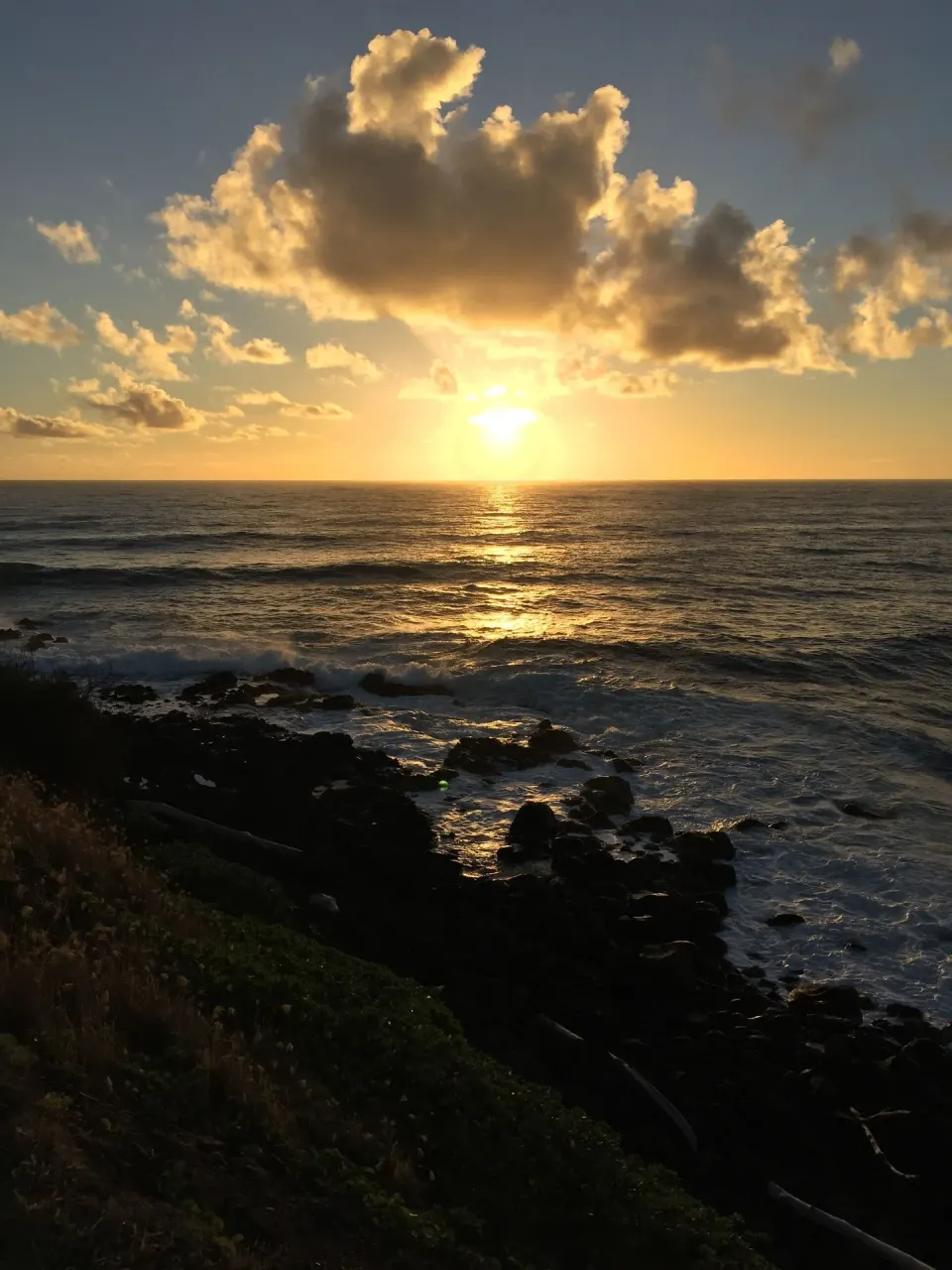 Rocky shoreline and bright ocean sunset at Hotel Coral Reef.