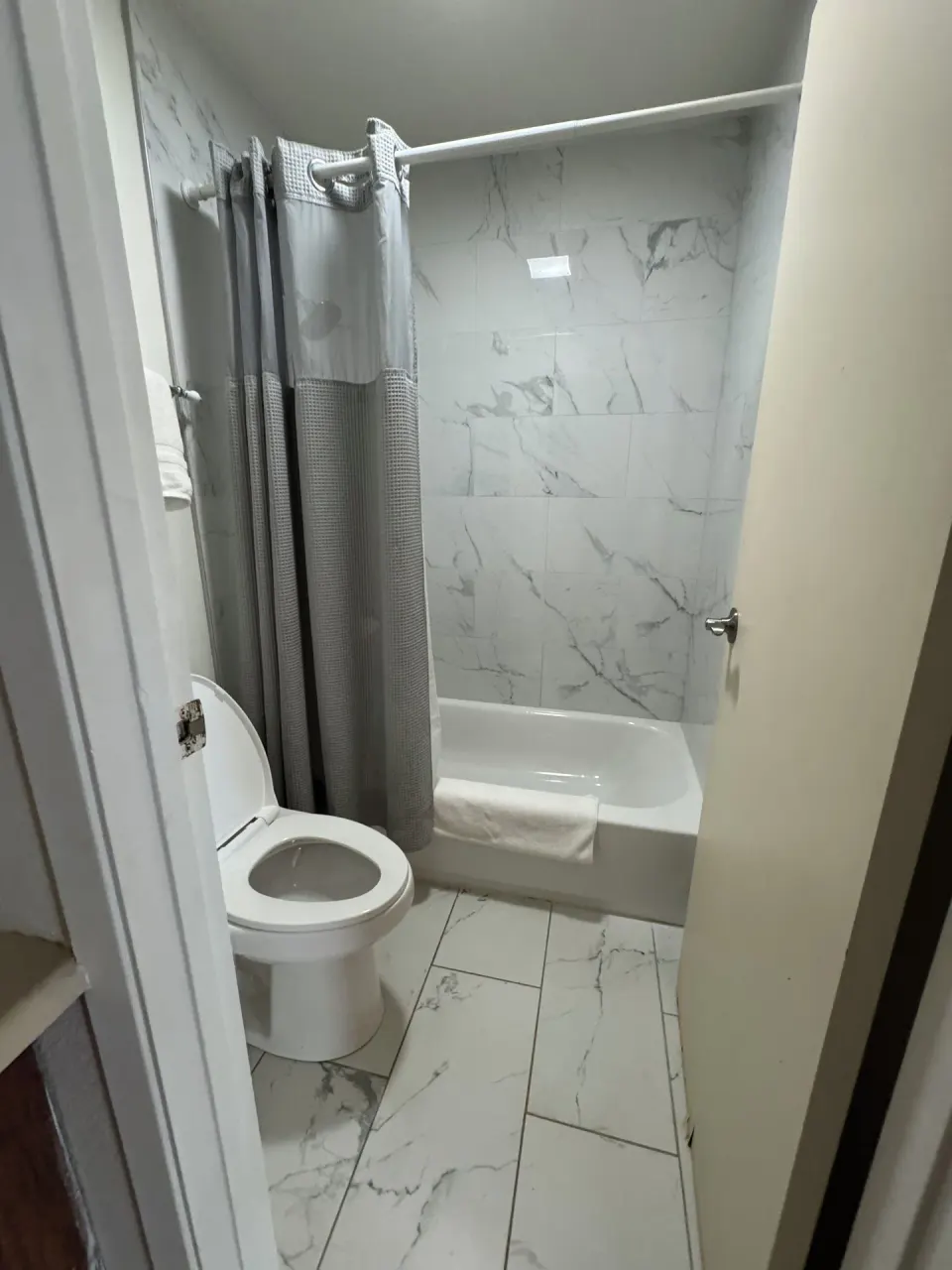 Economy Room bathroom with tub, shower curtain, and toilet at Hotel Coral Reef.