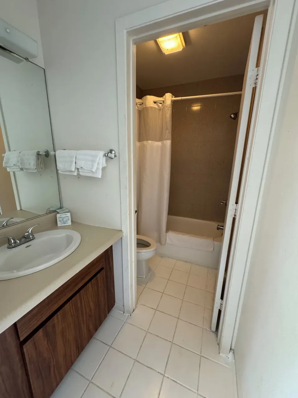 Economy Room bathroom vanity and tub-shower area at Hotel Coral Reef.