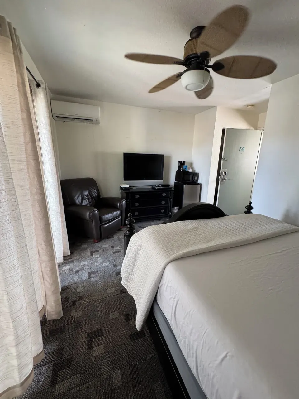 Economy Room City View with queen bed, TV, armchair, microwave, and mini fridge at Hotel Coral Reef.