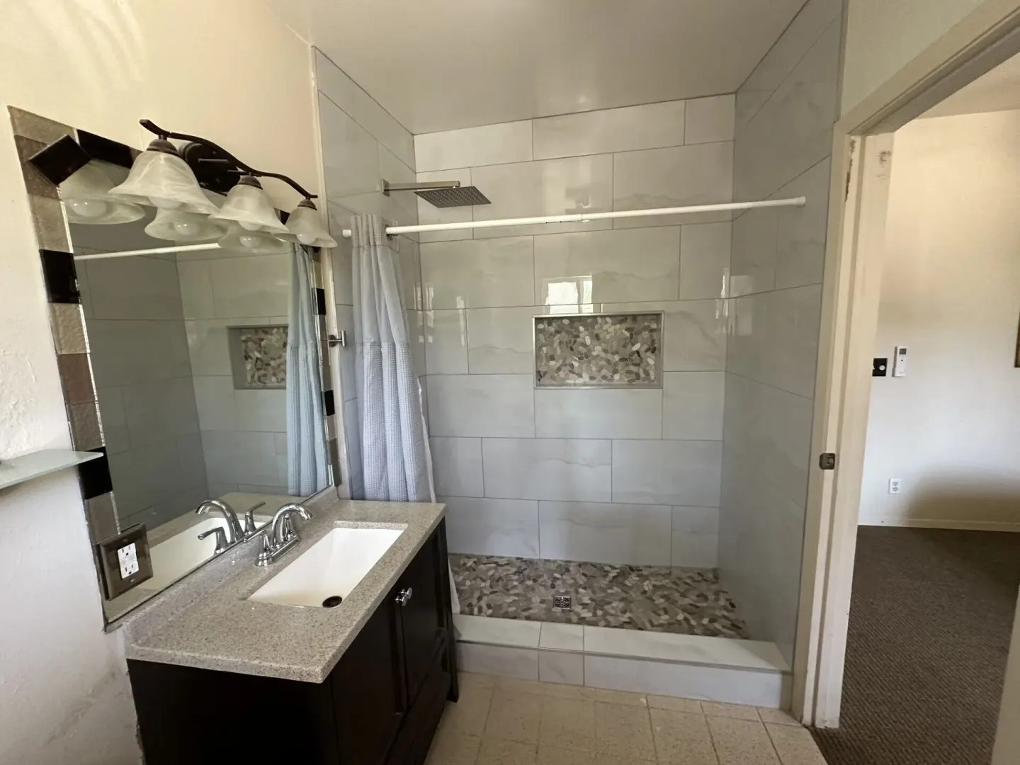 Economy Suite bathroom with tiled walk-in shower and vanity at Hotel Coral Reef.
