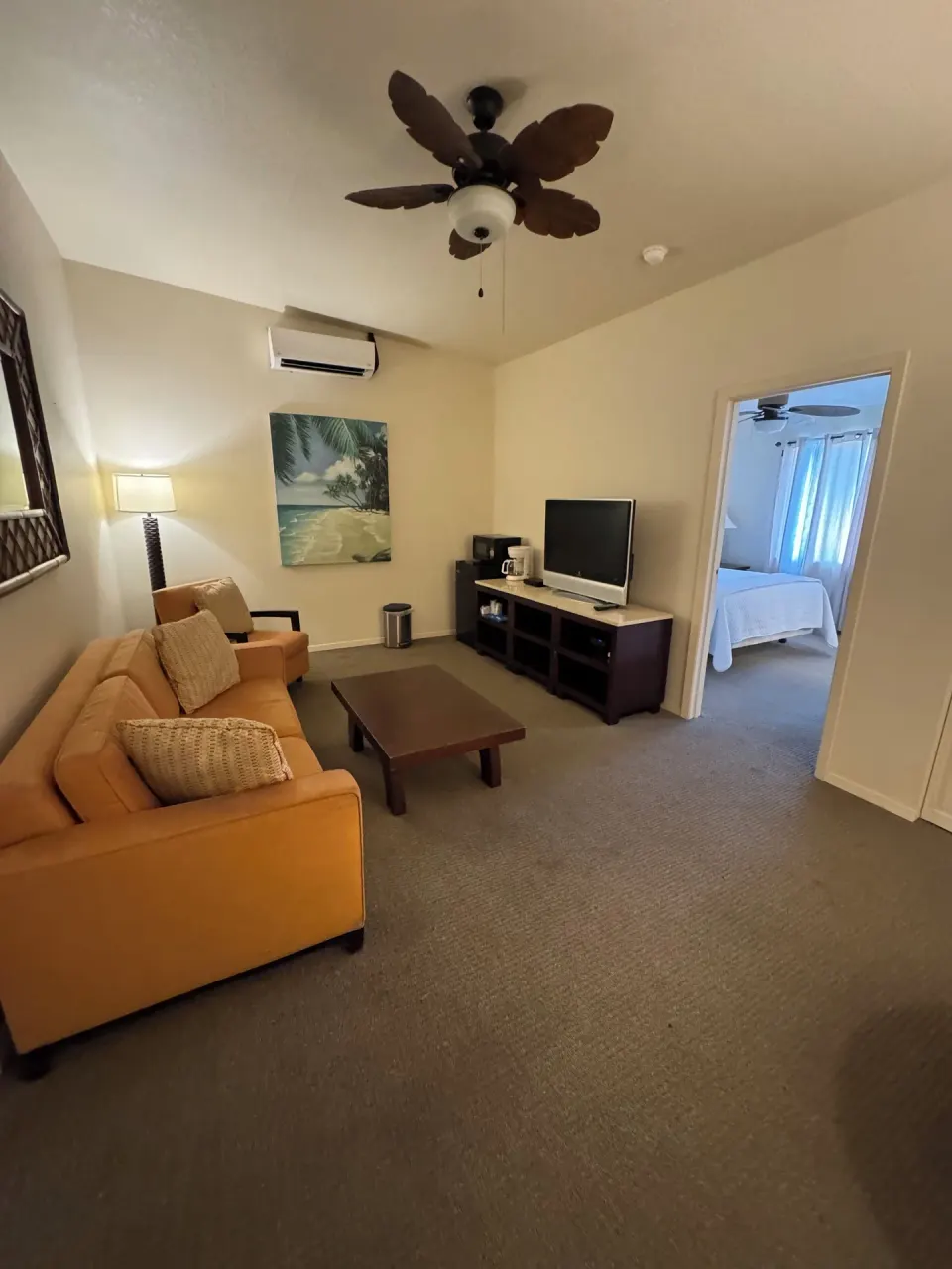 Economy Suite living area with sofa bed, TV console, and bedroom doorway at Hotel Coral Reef.