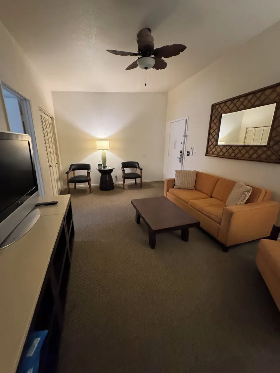 Economy Suite living room with sofa bed, TV, coffee table, and chairs at Hotel Coral Reef.
