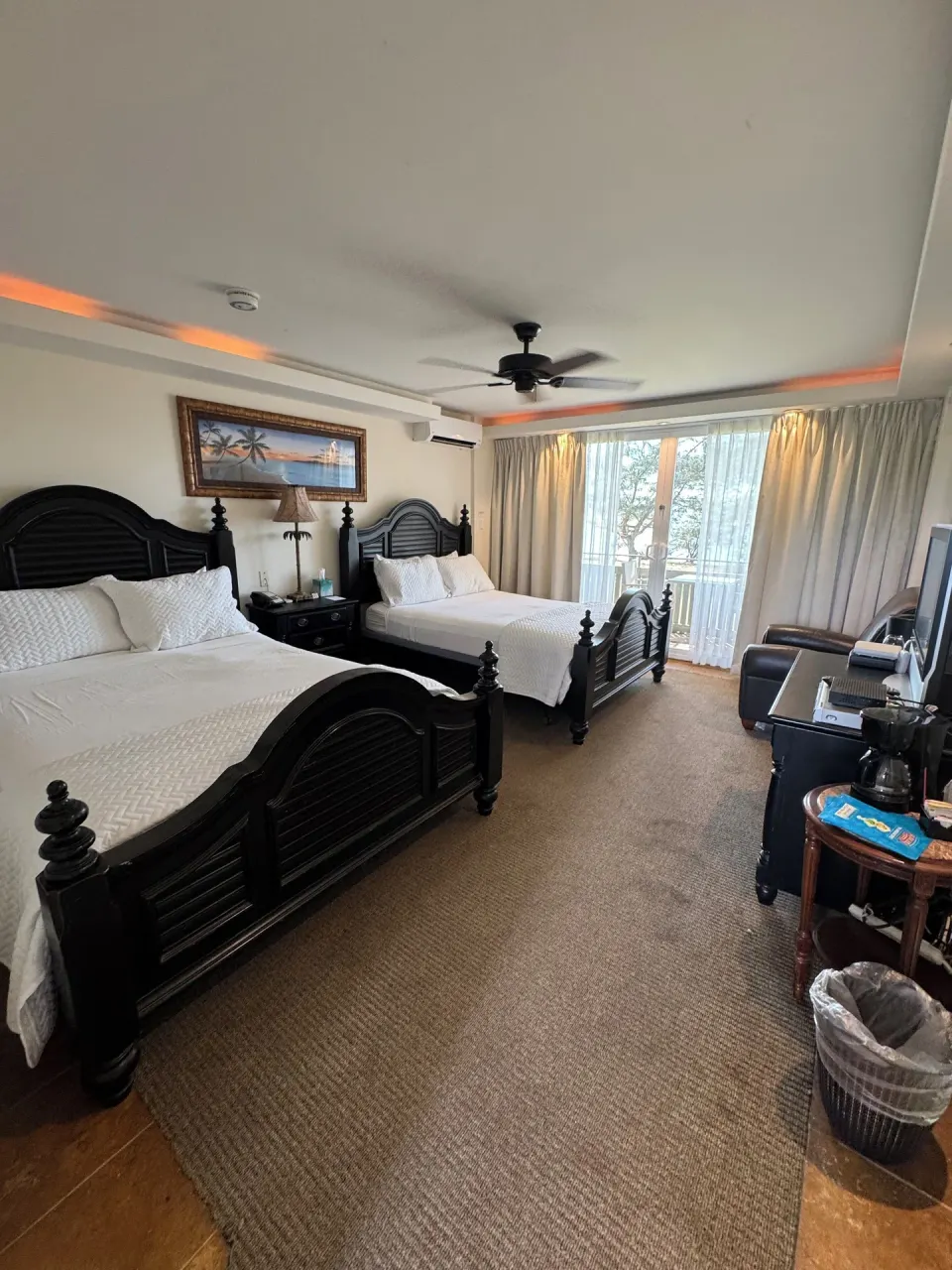 Oceanfront room with two beds, balcony doors, and seating at Hotel Coral Reef.