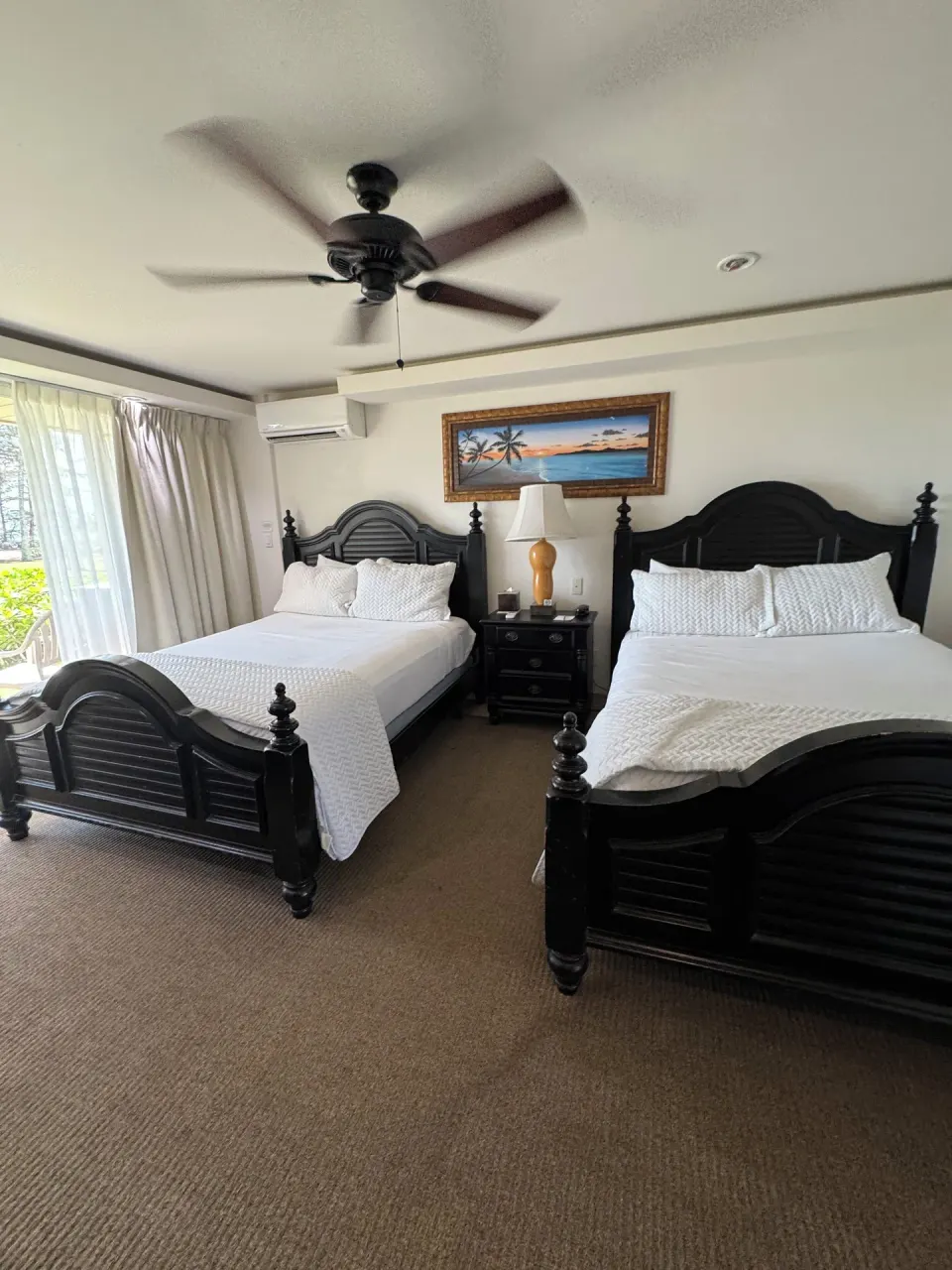 Oceanfront room with two beds near curtained balcony doors at Hotel Coral Reef.