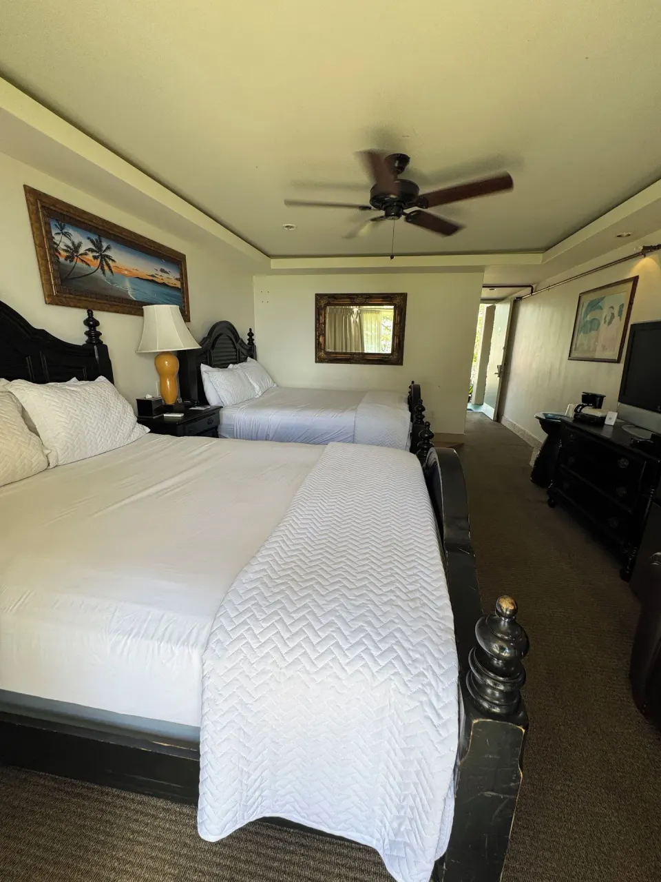 Two queen beds in a Panoramic Room at Hotel Coral Reef with dark wood furniture and ceiling fan.