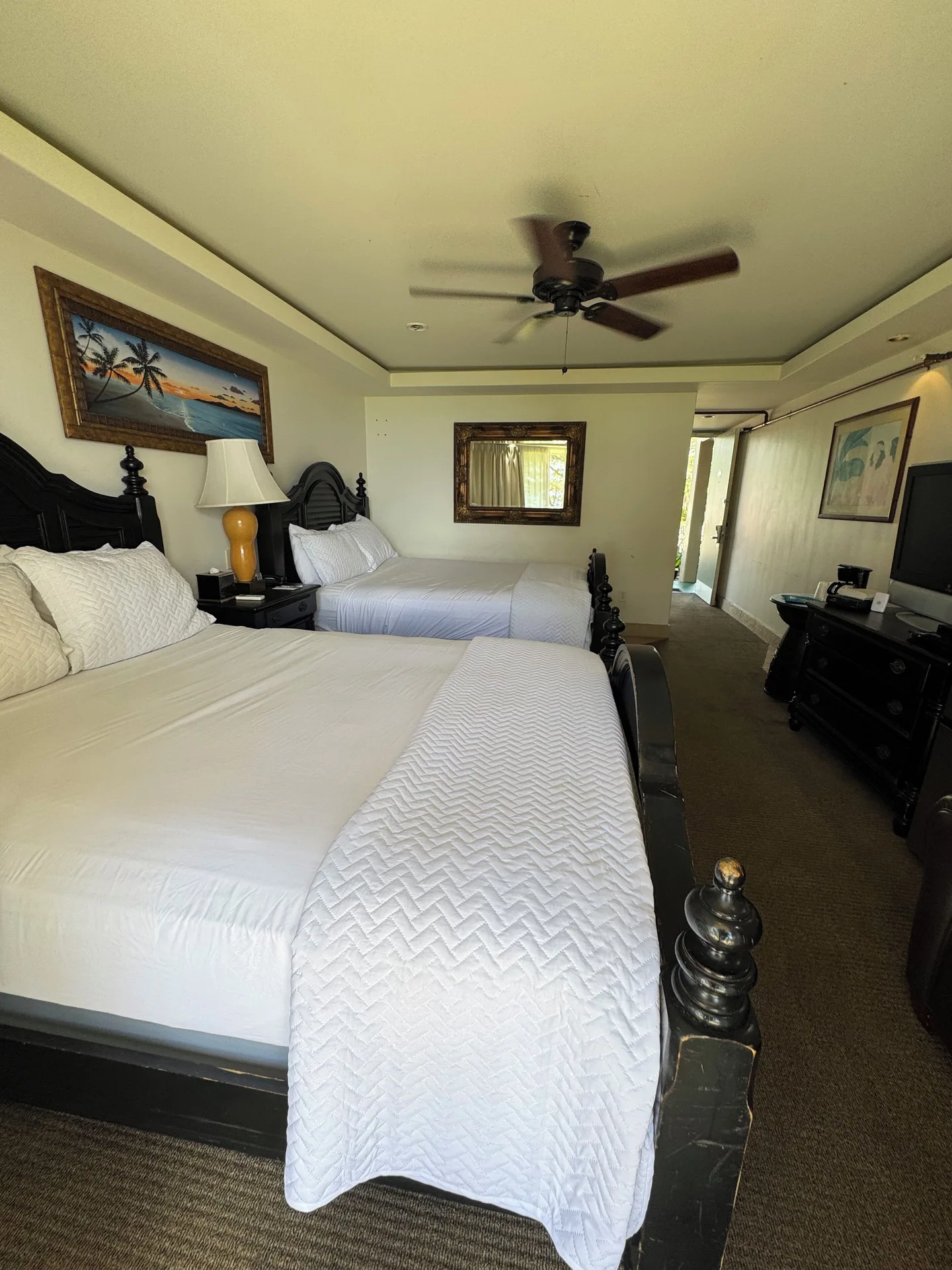 Two queen beds in a Panoramic Room at Hotel Coral Reef with dark wood furniture and ceiling fan.