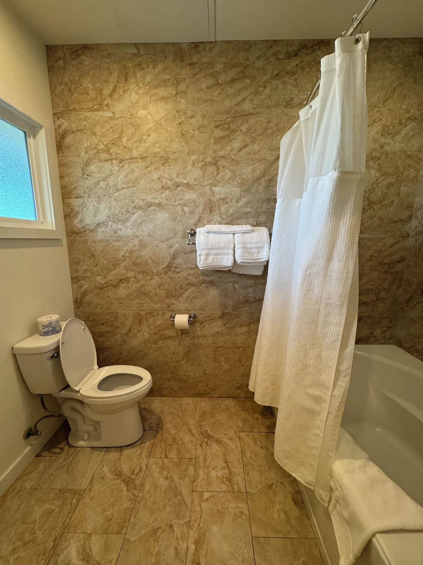 Premium Suite bathroom with toilet, towels, and shower curtain at Hotel Coral Reef.