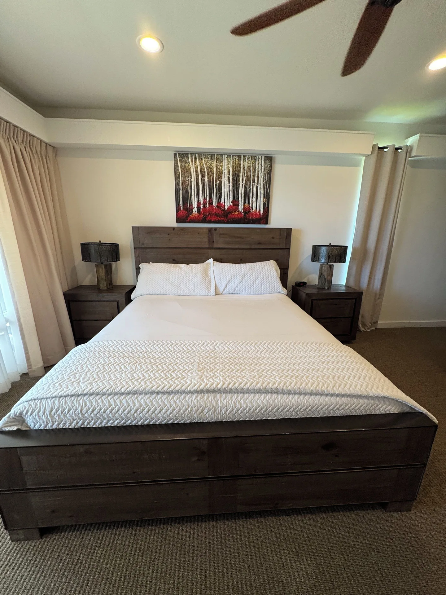 Premium Suite bedroom with large wood bed and bedside tables at Hotel Coral Reef.