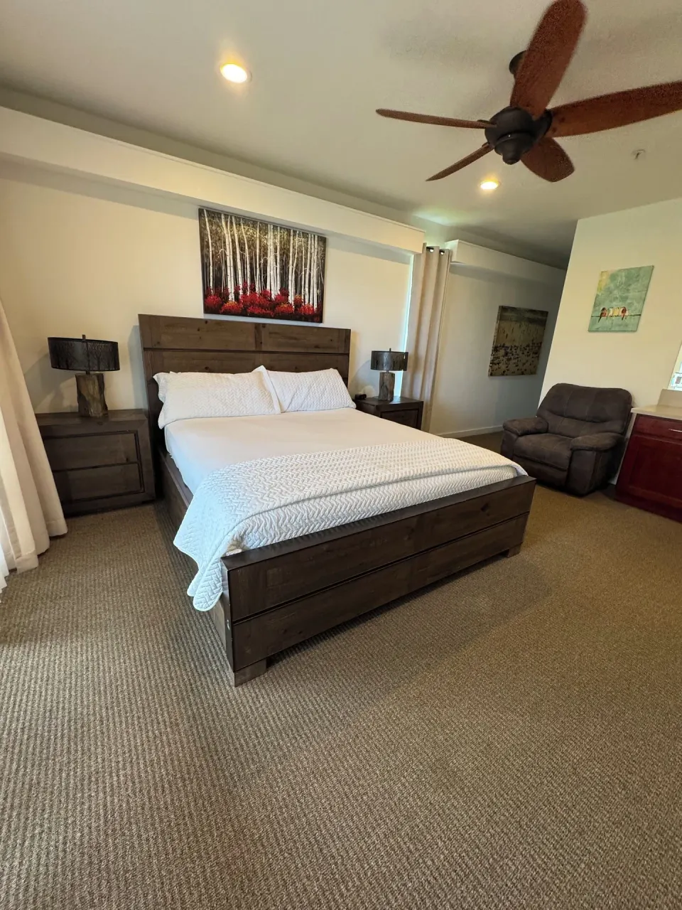 Premium Suite bedroom with king bed, nightstands and recliner at Hotel Coral Reef.