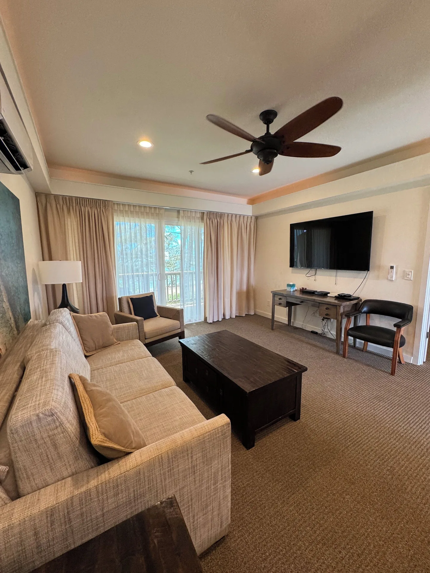 Premium Suite living room with sofa, TV and balcony doors at Hotel Coral Reef.