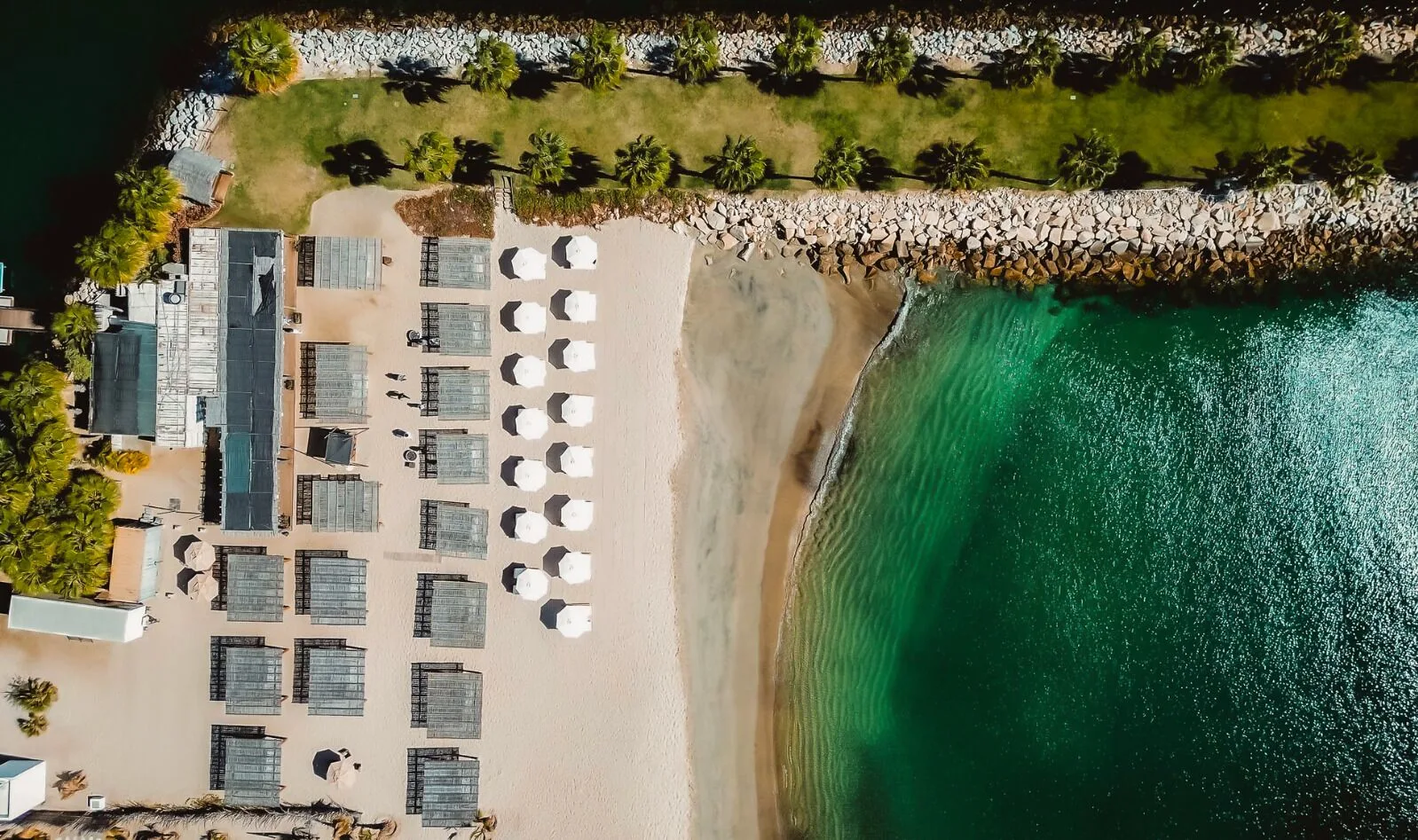Aerial view of beach umbrellas, cabanas, and turquoise water at Hotel El Ganzo.