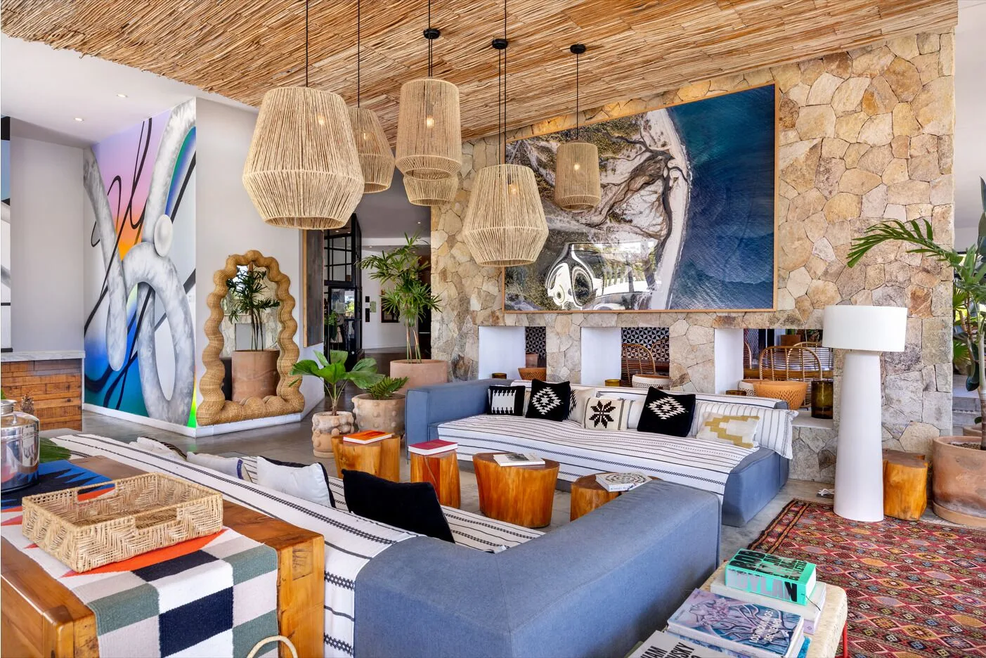 Art-filled lobby lounge with sofas and woven pendants at Hotel El Ganzo.