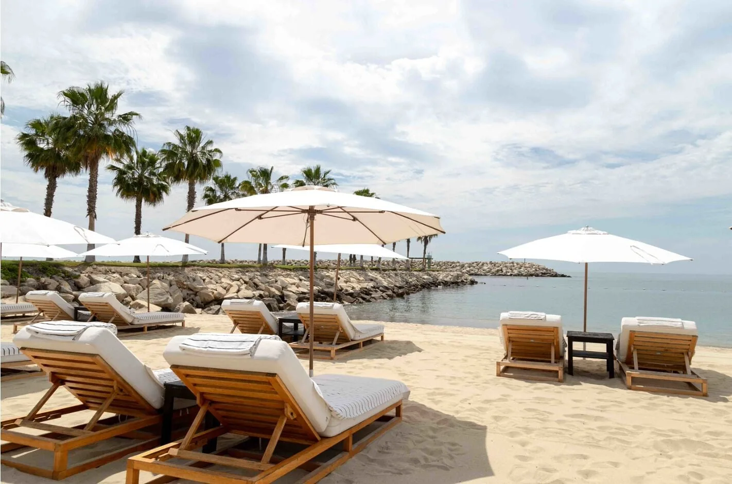 Beach loungers and white umbrellas on the sand at Hotel El Ganzo.